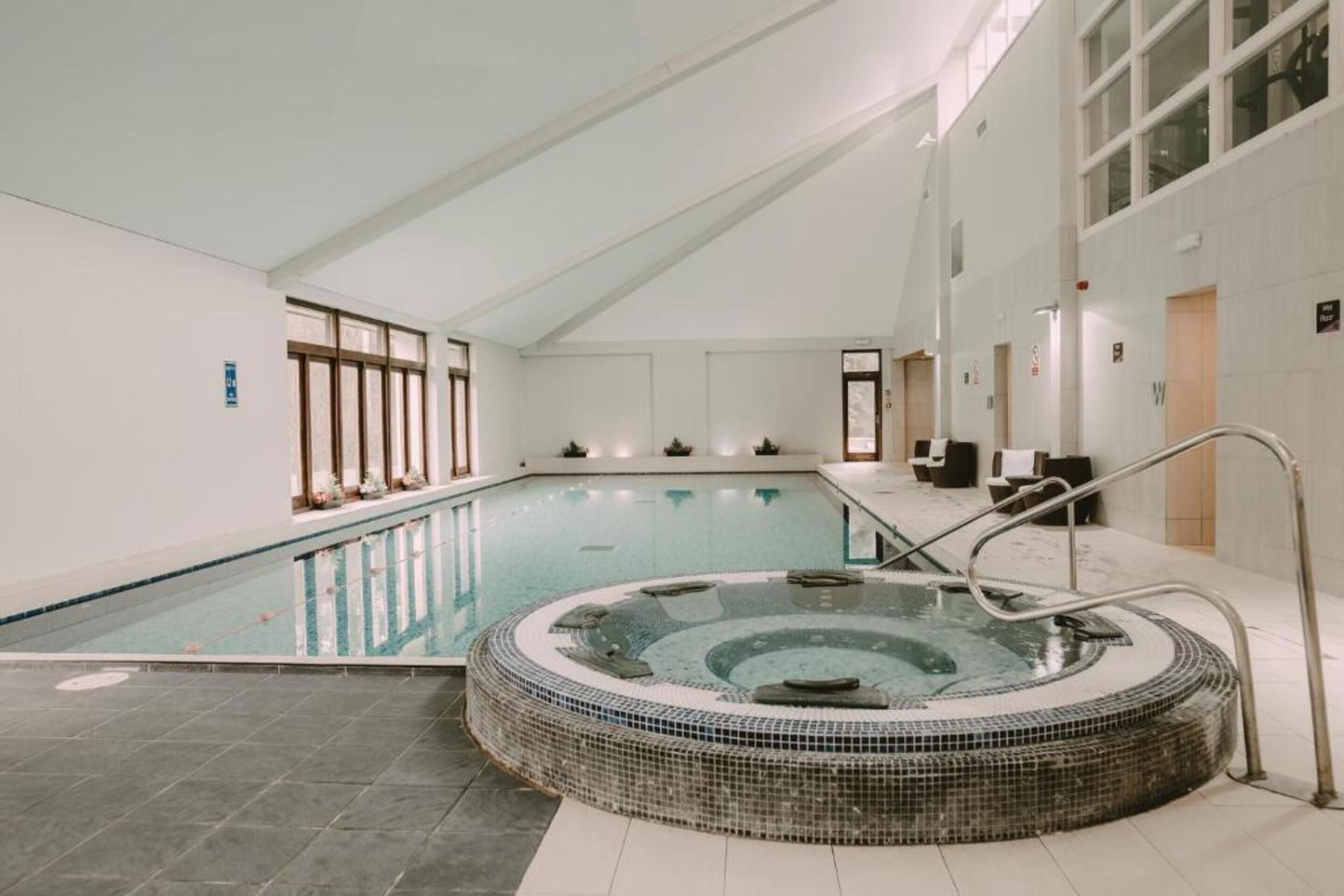 Una piscina techada, sillones reclinables de piscina