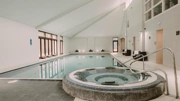 Una piscina techada, sillones reclinables de piscina