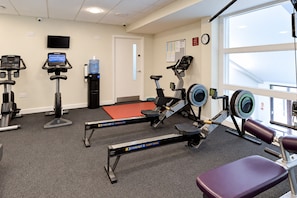 A gym with various exercise equipment, a water dispenser, and a large window providing natural light. - Nant Ddu Lodge Hotel & Spa by Belvilla (Merthyr Tydfil)
