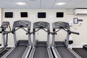 Three treadmills in a gym with wall-mounted televisions and a hand sanitizer dispenser. - Nant Ddu Lodge Hotel & Spa by Belvilla (Merthyr Tydfil)