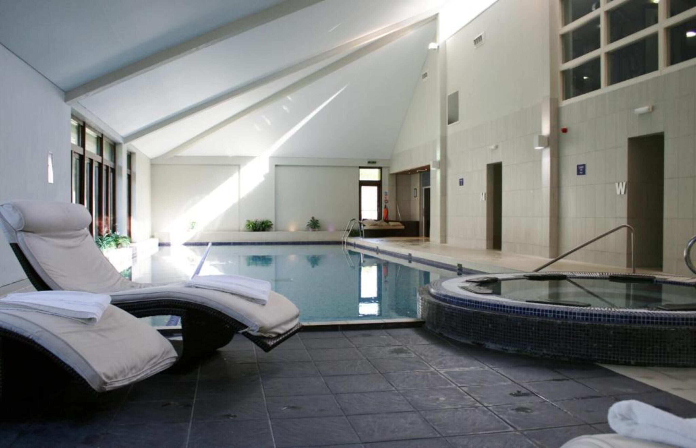Una piscina techada, sillones reclinables de piscina