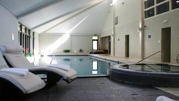 Una piscina techada, sillones reclinables de piscina