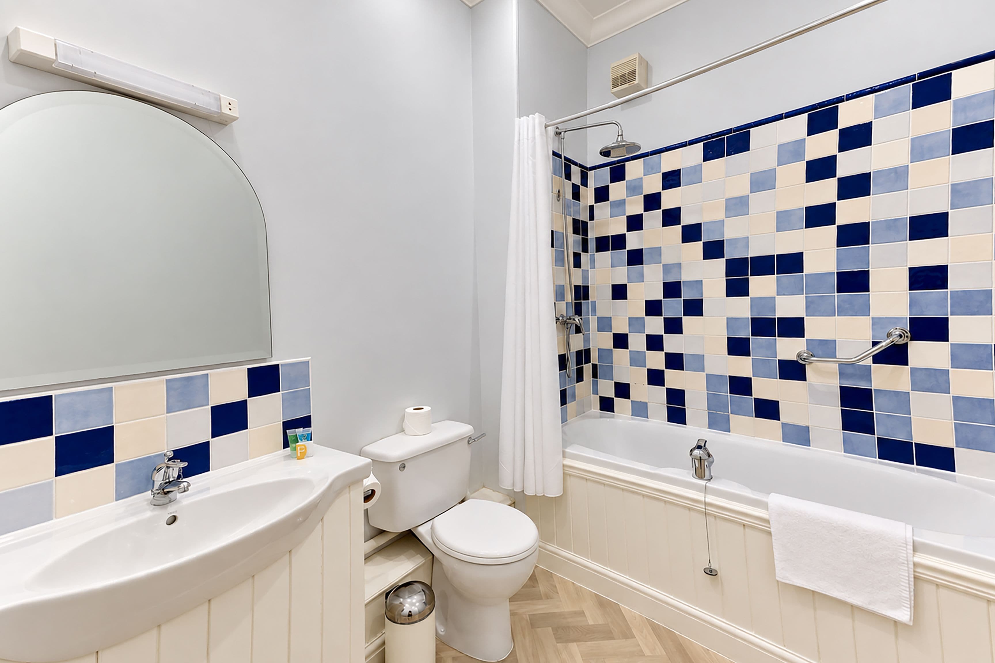 A bathroom with a sink, toilet, and shower area.