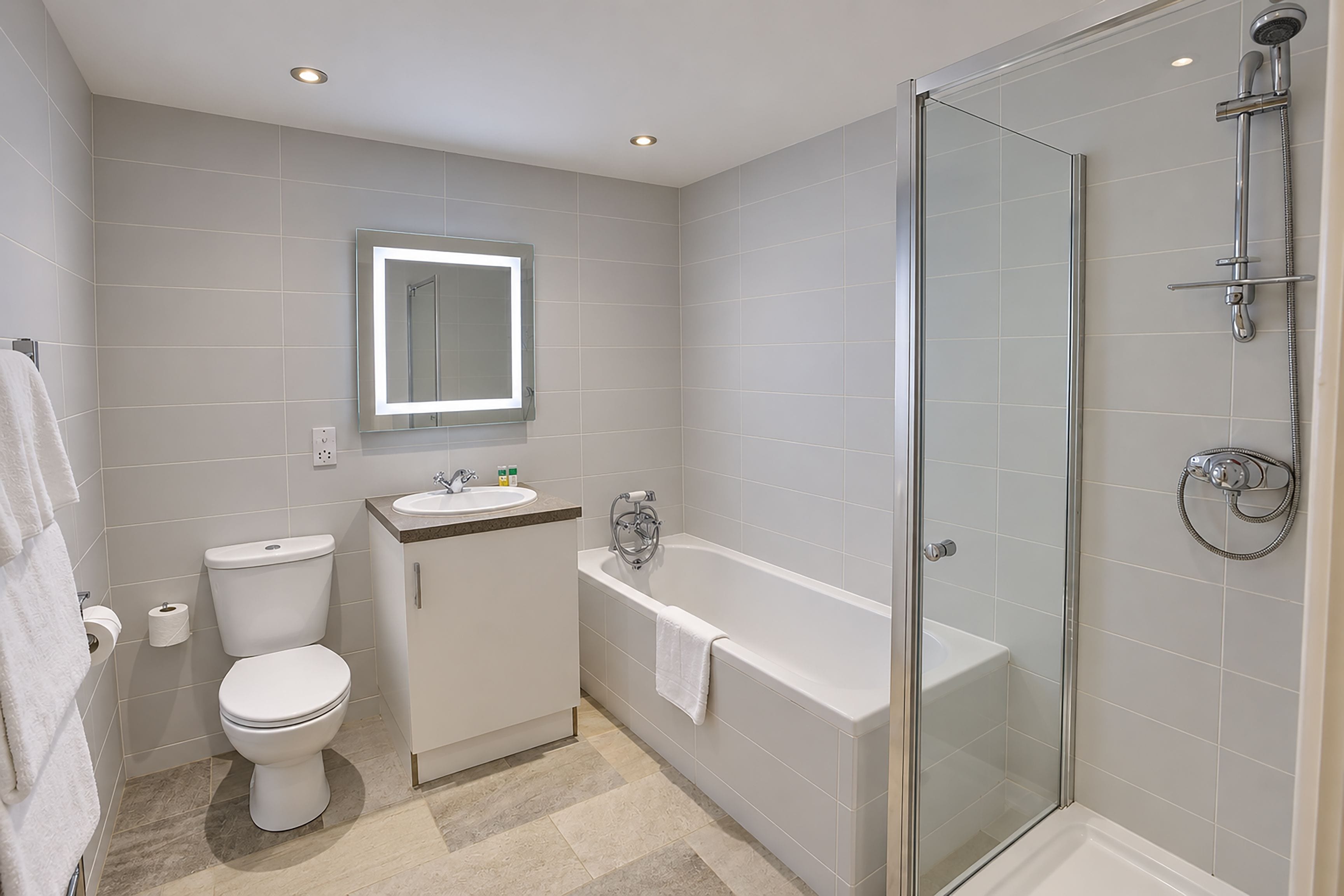 A modern bathroom with a toilet, sink, and shower.