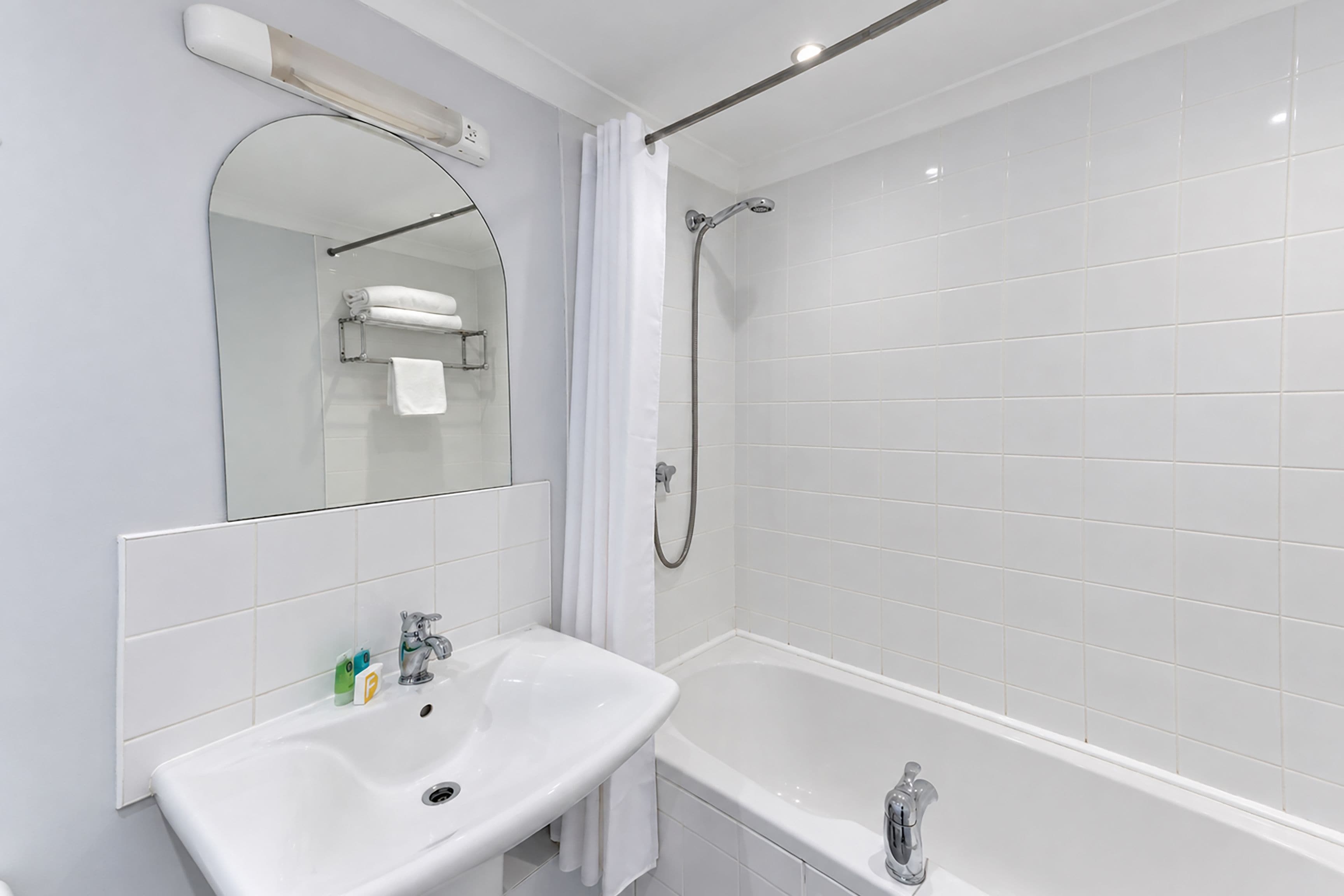 Une salle de bain moderne avec un lavabo blanc, une baignoire et une douche.