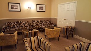 A room with a sofa set, striped armchairs, and a door. - Nant Ddu Lodge Hotel & Spa by Belvilla (Merthyr Tydfil)