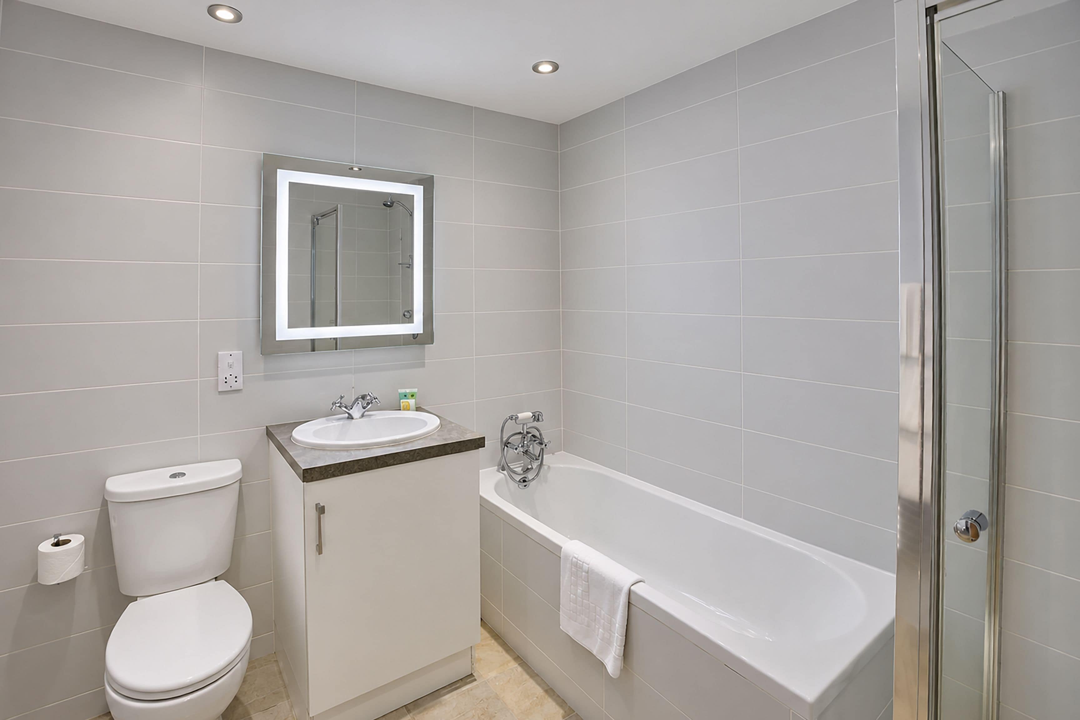 A bathroom with a toilet, sink, and bathtub.