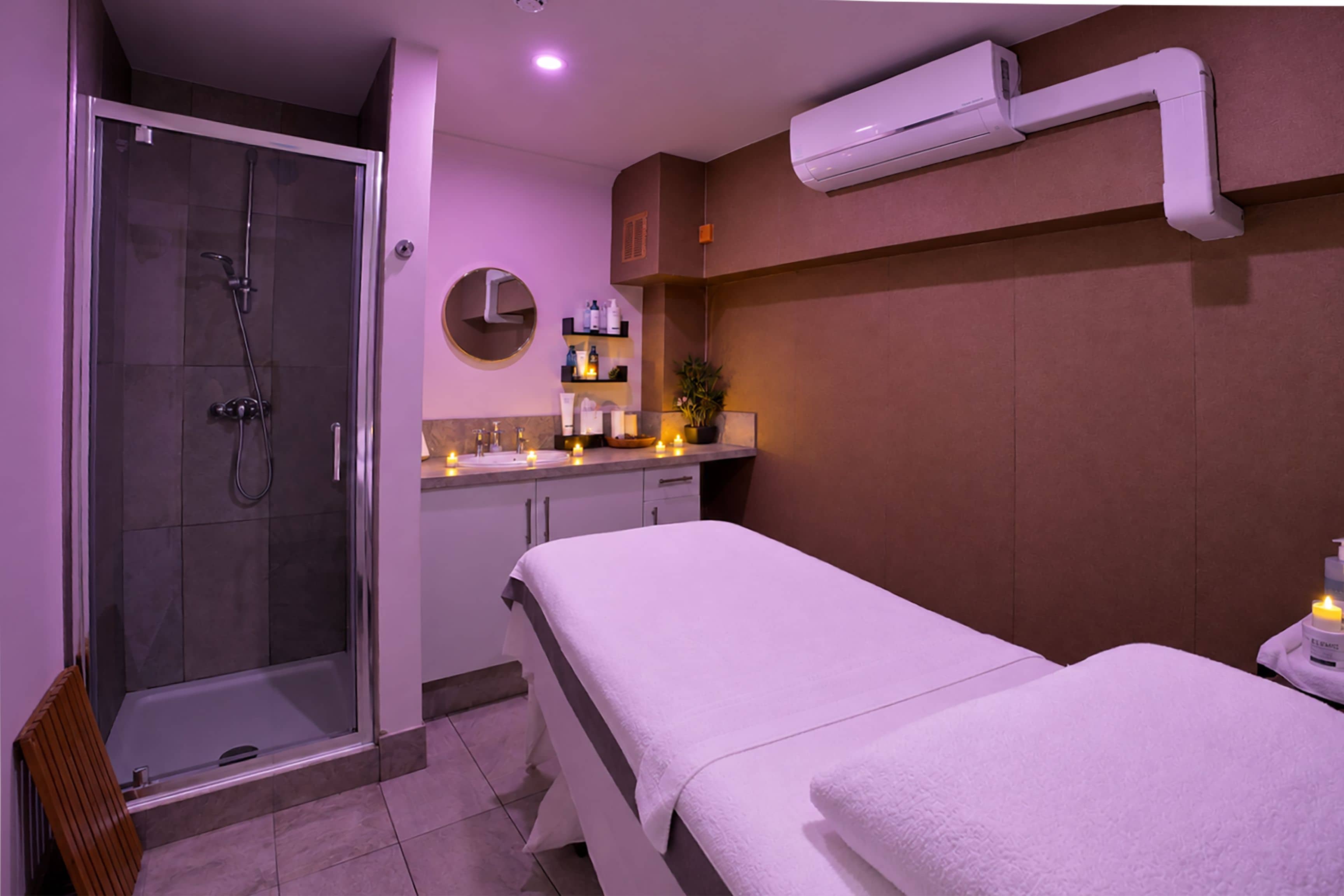 A modern bathroom with a glass-enclosed shower, a white bathtub, and a vanity with a mirror and shelves.