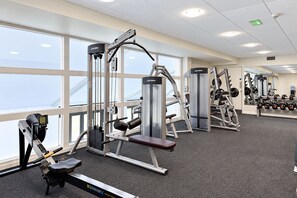 A gym with various exercise machines, large windows, and a carpeted floor. - Nant Ddu Lodge Hotel & Spa by Belvilla (Merthyr Tydfil)