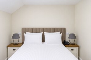 A hotel room with a bed, two bedside tables, a telephone, and a lamp on each side. - Nant Ddu Lodge Hotel & Spa by Belvilla (Merthyr Tydfil)