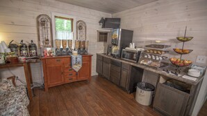 A rustic kitchen with wooden cabinets, a coffee station, and a fruit bowl.