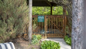 A wooden deck with a sign indicating Whirlpool hours and a lifeguard duty notice.
