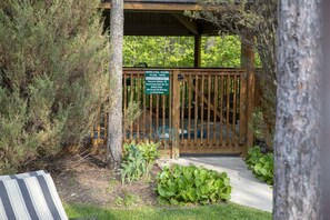 A wooden deck with a sign indicating Whirlpool hours and a lifeguard duty notice.