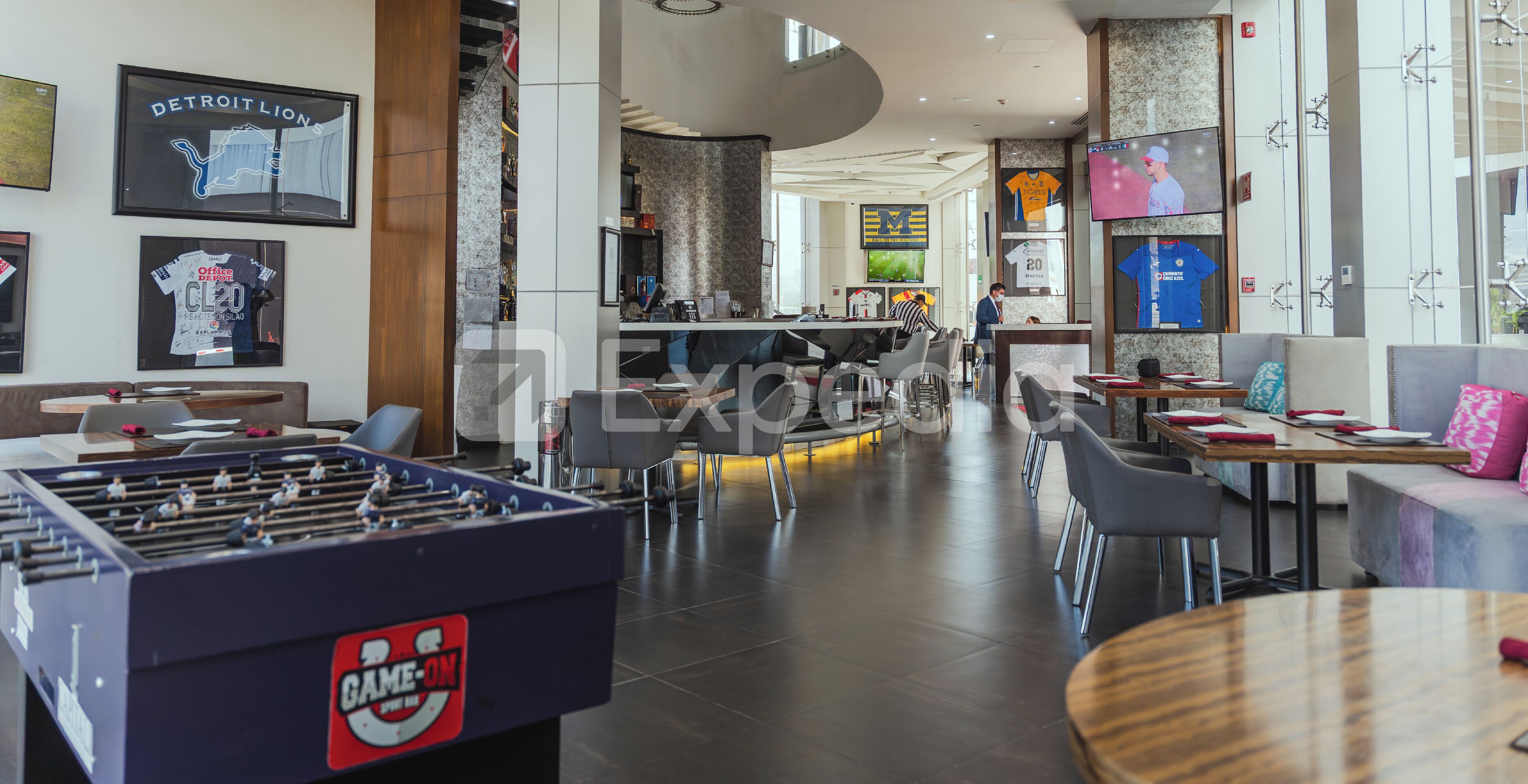 Un hall d’hôtel moderne doté d’un baby-foot, d’espaces de détente et d’un bar.