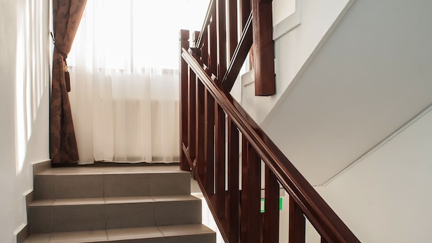 A staircase with wooden railings and beige steps. - Ceramica Hotel (Iasi)
