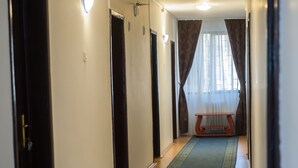 A hallway with a carpet, doors, and a bench. - Ceramica Hotel (Iasi)