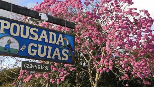 Schild für 'Pousada Guias' mit einer Kontaktnummer.