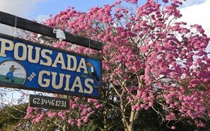 Un cartel que indica 'Pousada Guias' con un número de contacto.