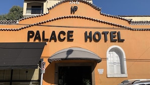 The exterior of the Palace Hotel with a sign indicating it is open all days. - Palace Hotel Angra (Angra dos Reis)