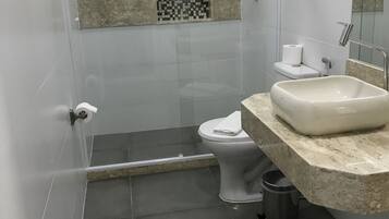 A bathroom with a shower, toilet, and sink.