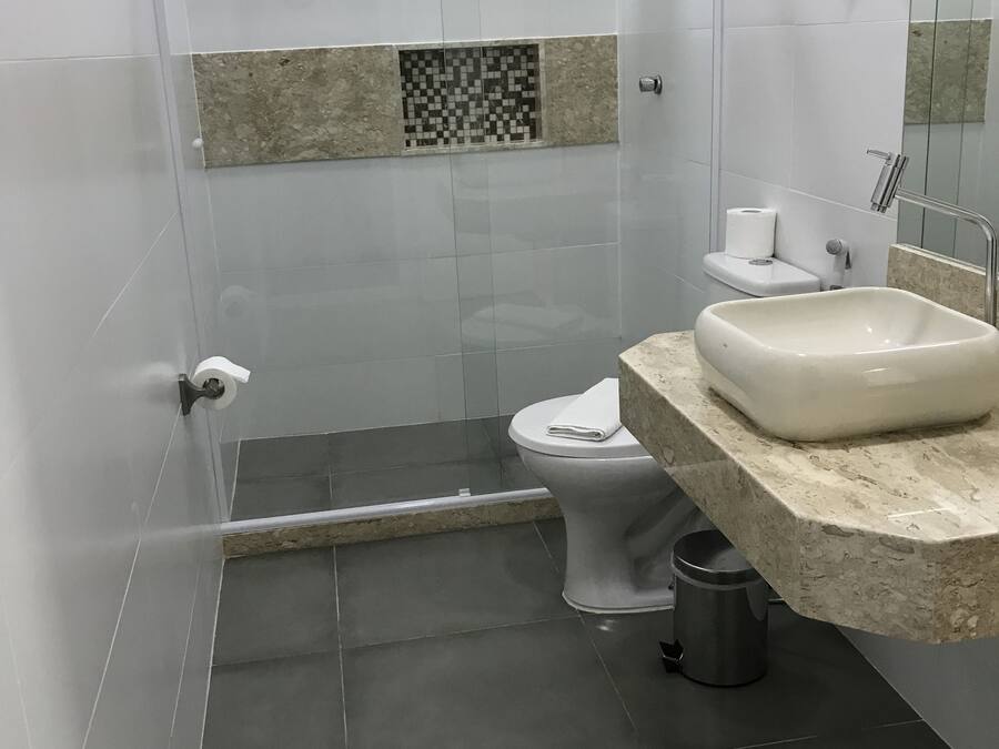 A bathroom with a shower, toilet, and sink.