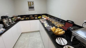 A hotel kitchen with a buffet setup, including various food items and kitchen appliances. - Palace Hotel Angra (Angra dos Reis)