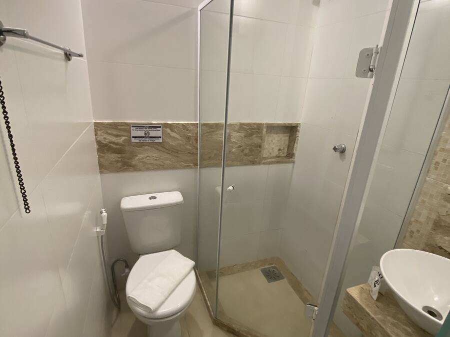 Een kleine badkamer met toilet, een douchecabine en een wastafel.