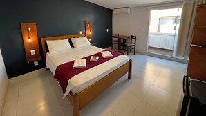 Een slaapkamer met een bed, nachtkastjes, een bureau en een stoel.