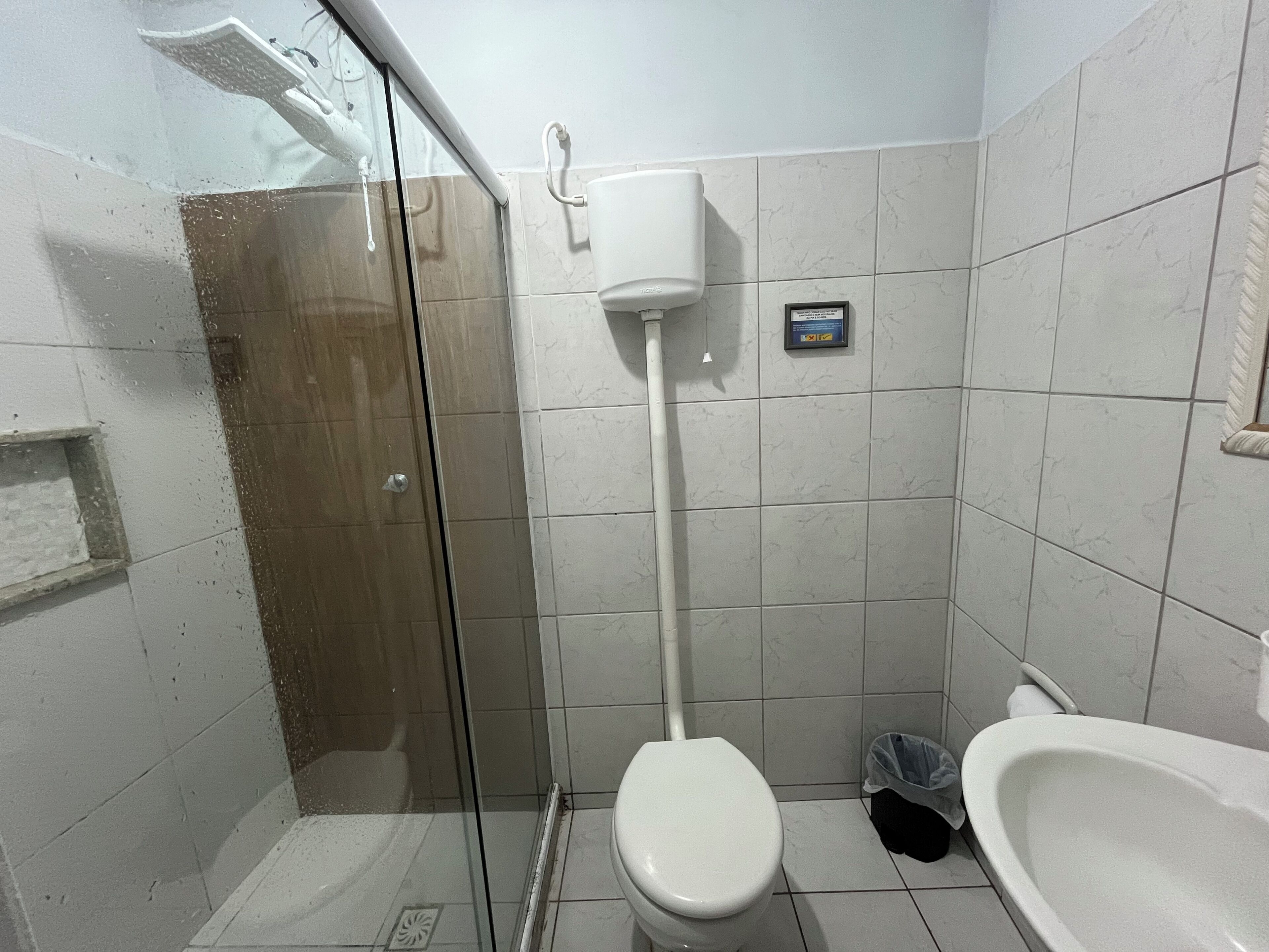 Un baño pequeño y funcional con inodoro, bidé y cabina de ducha de cristal.