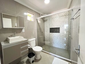 A modern bathroom with a glass shower enclosure, a toilet, and a sink. - Pousada Vila Appia (Cabo Frio)