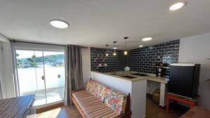 Een moderne keuken met een centraal eiland, een bank met bloemenprint en een eettafel.