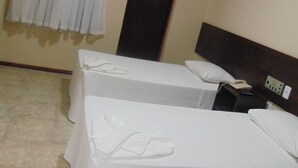 A hotel room with two beds, a nightstand, a telephone, and an air conditioning unit. - Alvorada Palace Hotel (Cuiabá)
