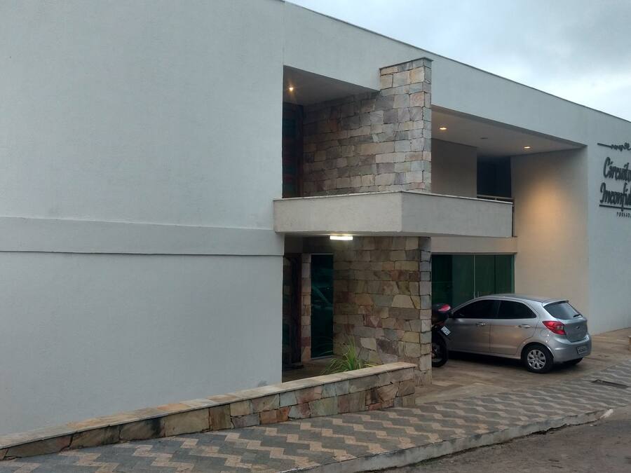 Un bâtiment moderne avec une façade en pierre et une voiture garée devant.