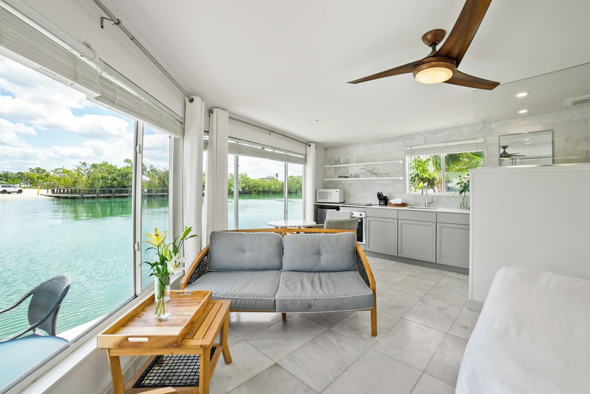 Una habitación moderna con sofá, mesa de comedor y vistas al agua.