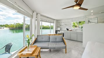 Una habitación moderna con sofá, mesa de comedor y vistas al agua.