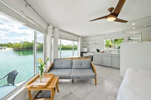 A modern room with a sofa, dining table, and a view of the water. - Casey Key Resort  (Nokomis)