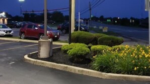A yellow sign for Norwalk Inn with an arrow pointing left, indicating the entrance direction. - Norwalk Inn (Norwalk)