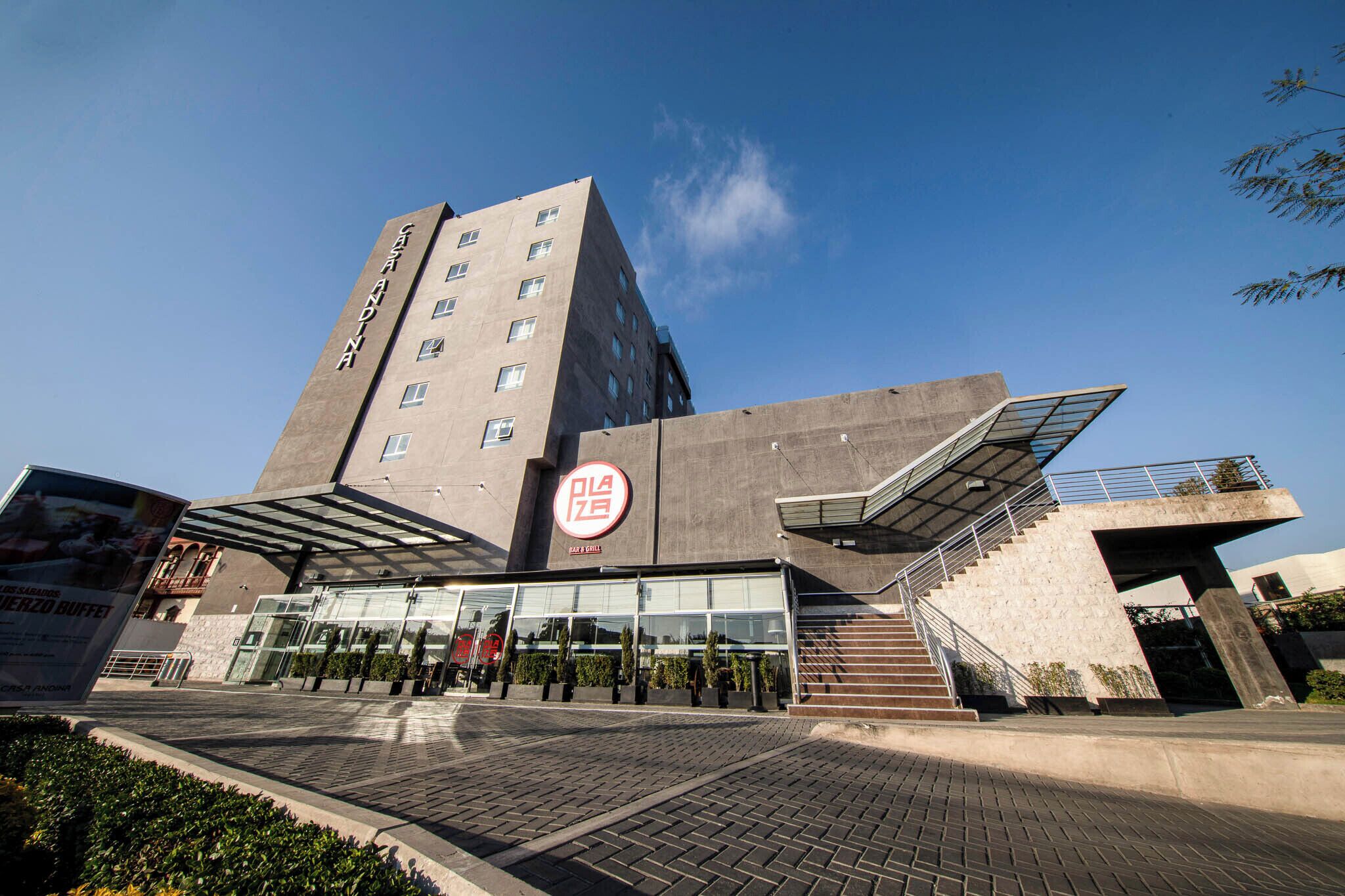 A modern building with a prominent entrance, a large glass facade, and a staircase leading to an upper level.