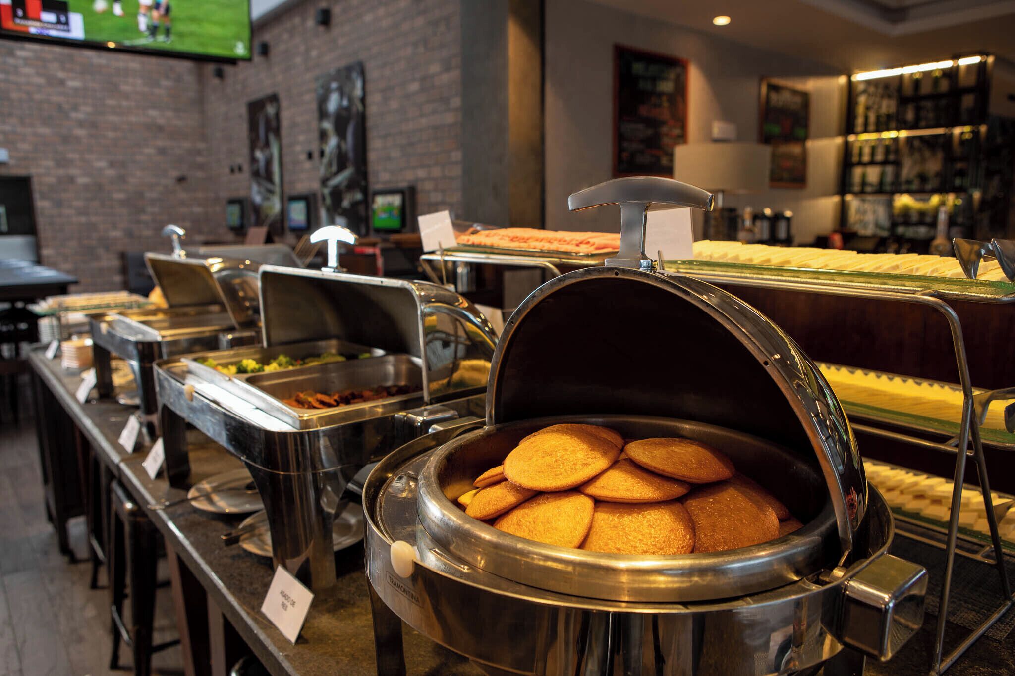 A buffet area with various food stations, including a large pot of cookies and a tray of sandwiches.