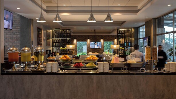 A buffet area with various food and drink options, including fruit, beverages, and a coffee station. - Casa Andina Select Tacna (Tacna)