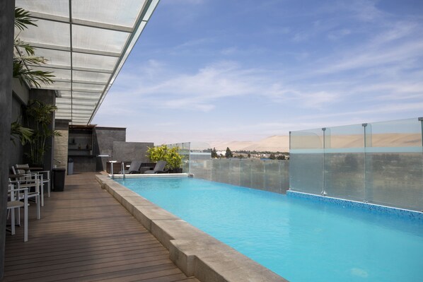 Alberca al aire libre y camastros