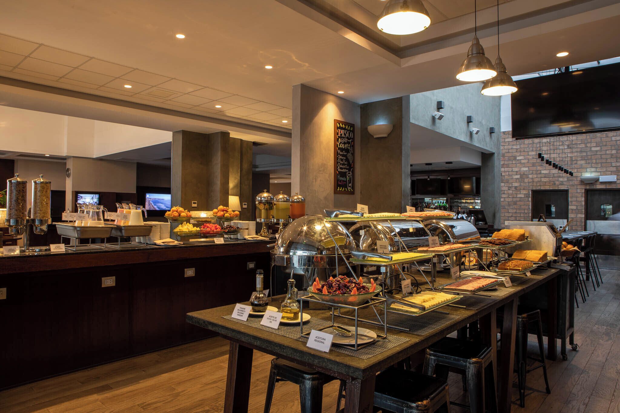 A buffet area with various food stations, including a fruit display and a salad bar.