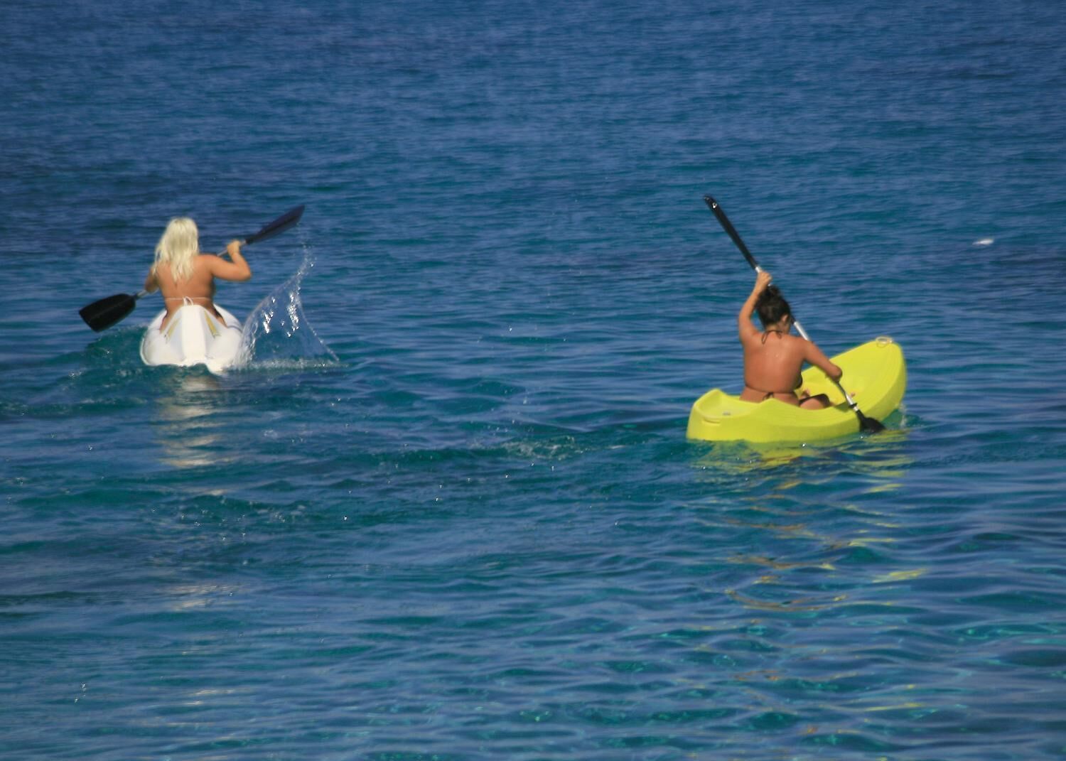 Two people kayaking in the ocean.