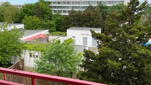 A multi-story building with a flat roof, surrounded by trees and a red railing. - Mures Saturn (Saturn)