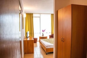 A bedroom with a bed, a wooden wardrobe, a desk, and a chair. - Mures Saturn (Saturn)