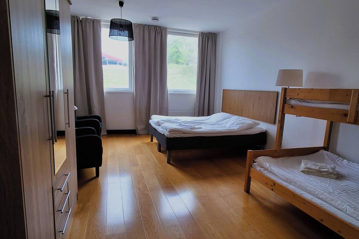 A room with a bed, a desk, a chair, a window, and a ceiling light.