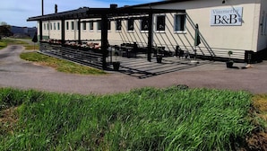 A building with a sign reading 'Vimmerby B&B' and a covered outdoor seating area.