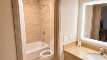 Ein Badezimmer mit Badewanne, Toilette, Waschbecken und einem großen Spiegel.