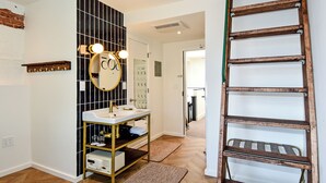 A bathroom with a vanity, mirror, and wooden ladder. - HighRoad Washington DC (Washington)