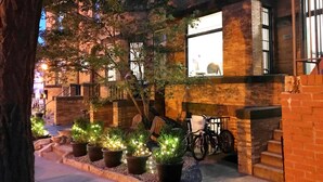 A building with brick walls, large windows, and outdoor seating. - HighRoad Washington DC (Washington)
